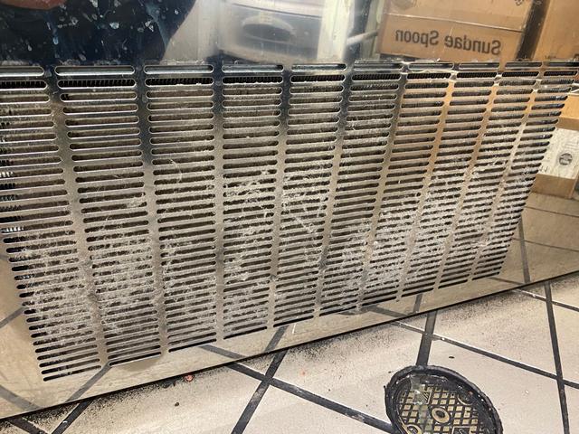 Front ventilation grille with visible dust.