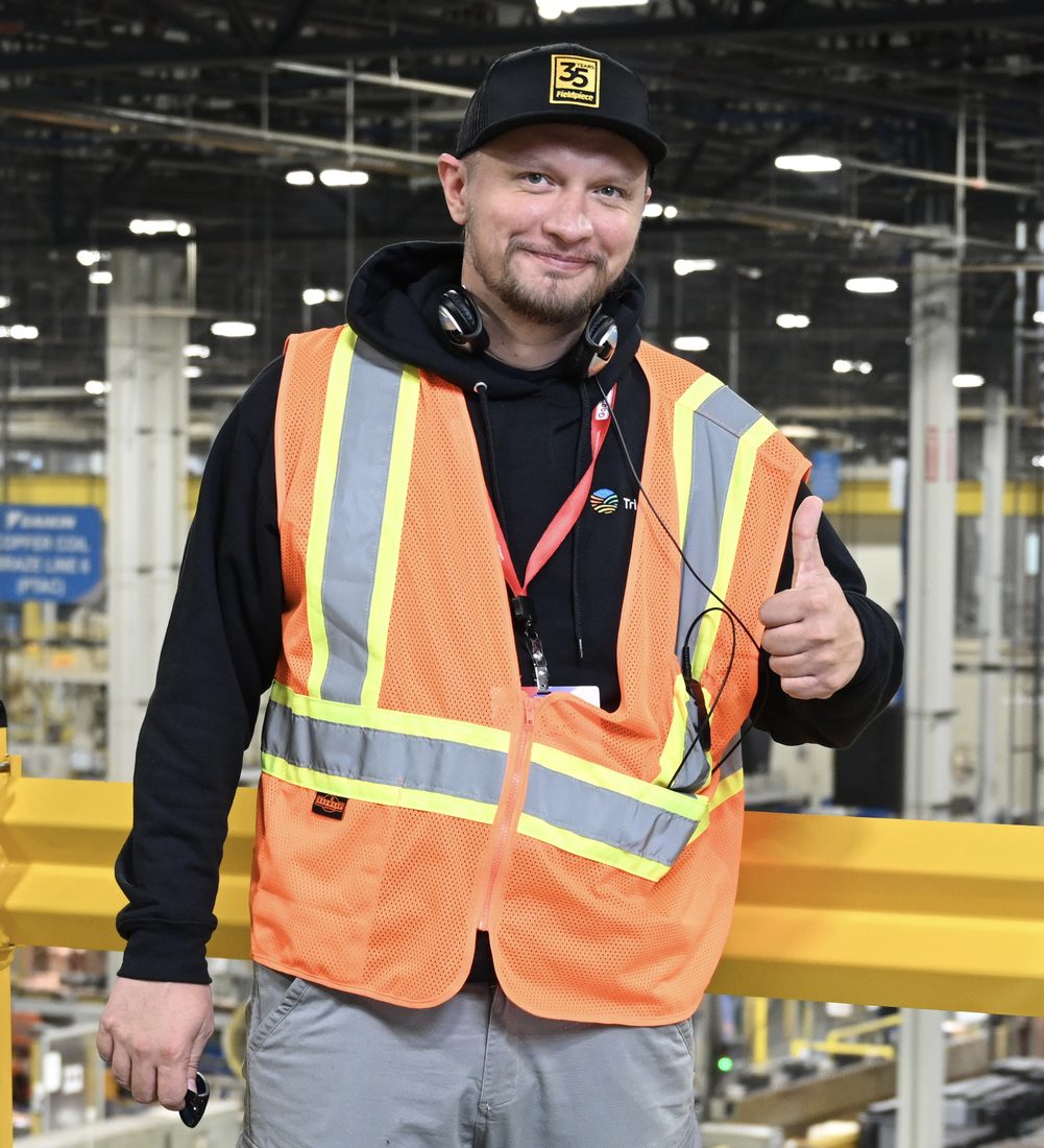 Andrew Kuznetsov, owner of ADRIUM Service Solutions, in a safety vest on the factory floor during manufacturer HVAC training