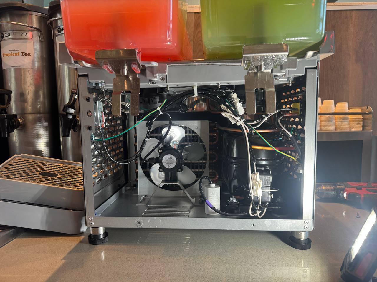 Inside the dispenser: the R290 sealed system, with the condenser, fan, and compressor, where the cooling fault was traced.