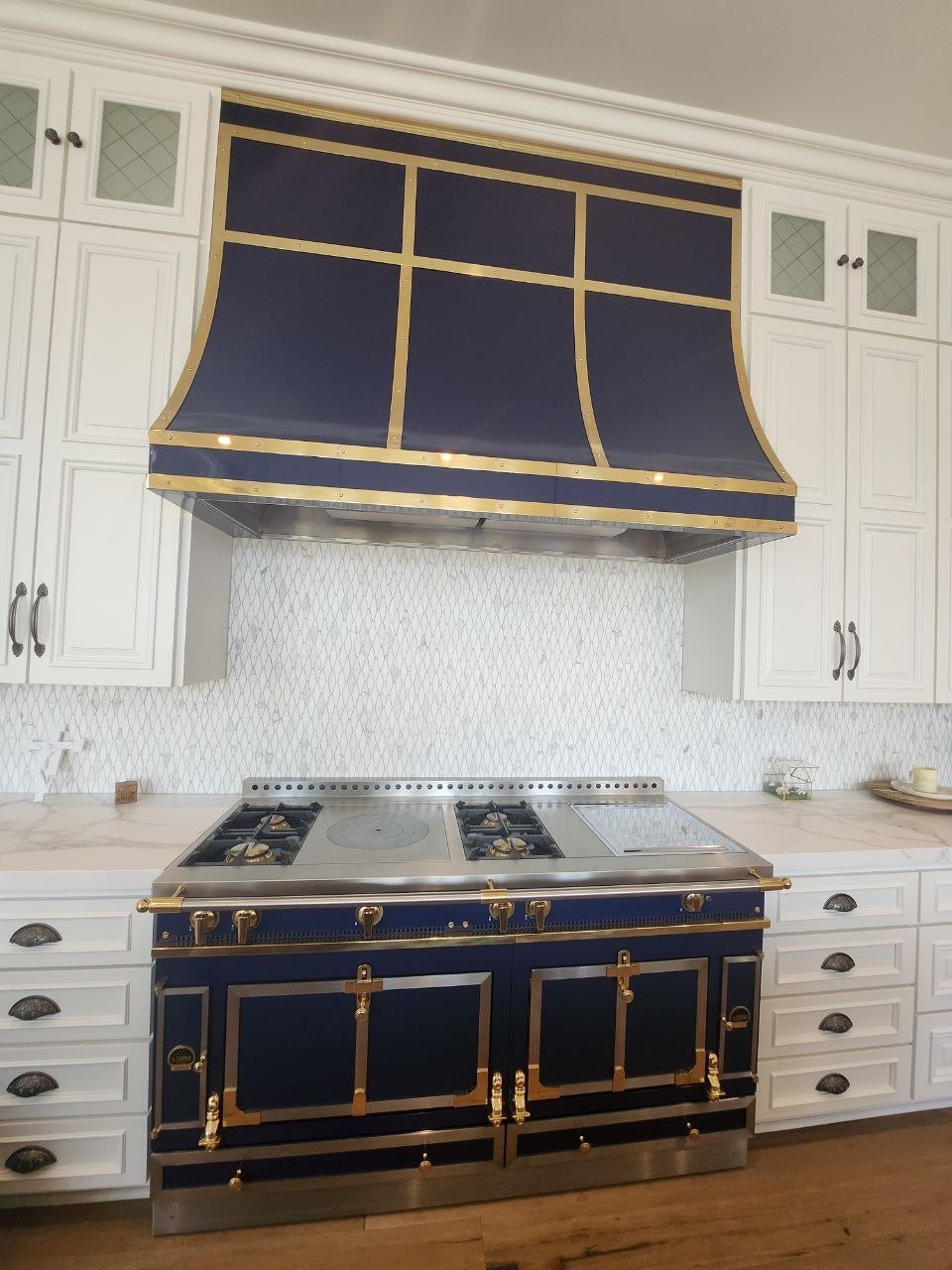 Blue La Cornue range with brass trim beneath a matching blue and brass hood