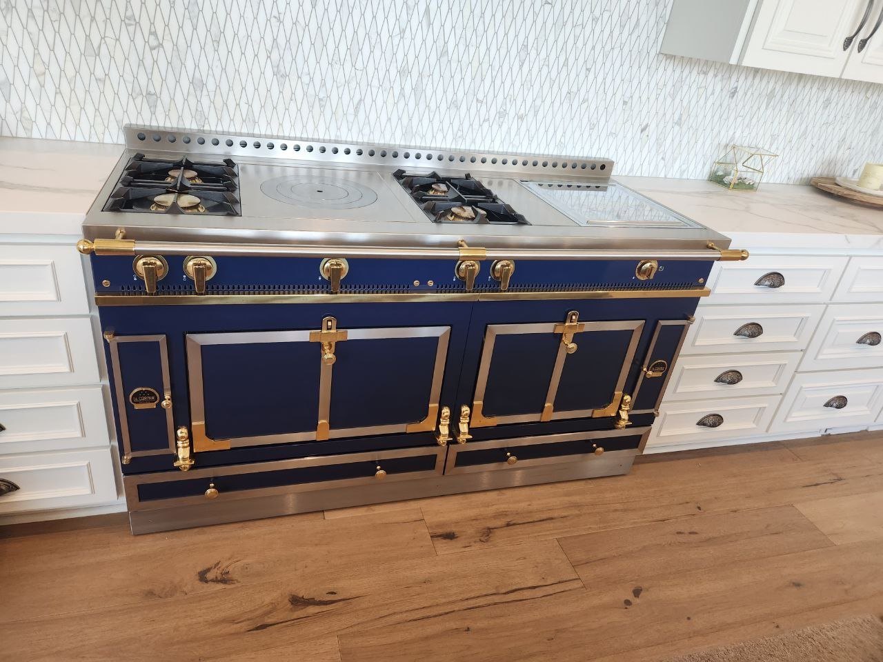 Front view of a blue La Cornue range with brass handles and trim