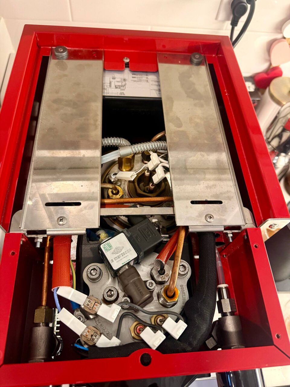 La Marzocco Linea Micra with the top panel open: boiler, saturated group, and La Marzocco-stamped valves exposed during service.