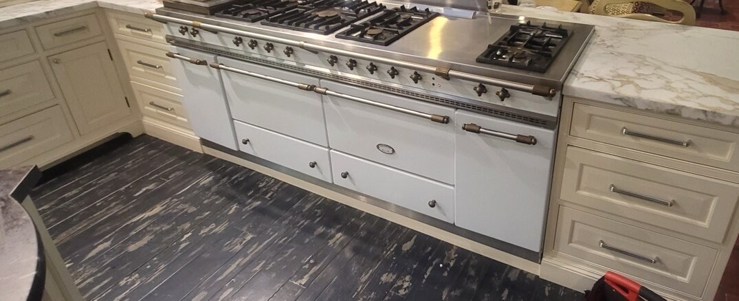 White Lacanche range with brass rails beside a marble counter