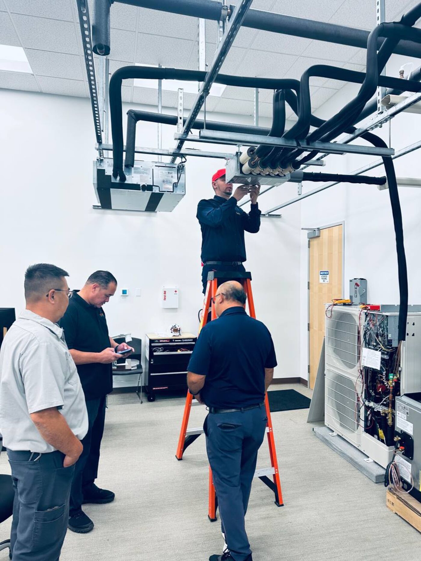Mitsubishi Electric factory training lab, working on a ceiling cassette and outdoor unit