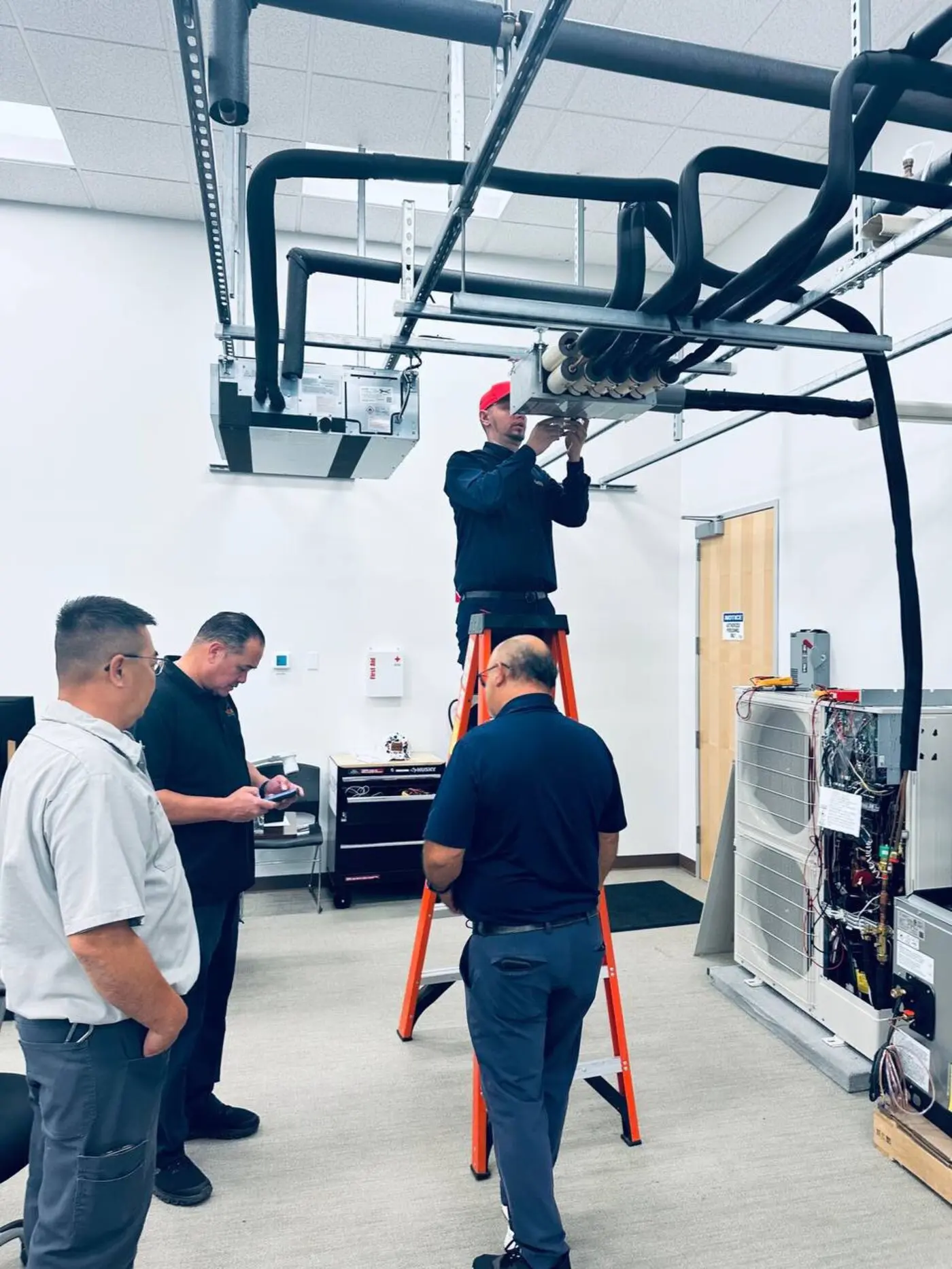 Mitsubishi Electric factory training lab, working on a ceiling cassette and outdoor unit