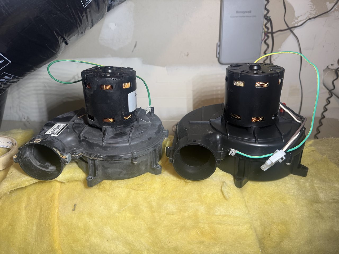 Old failed draft inducer motor next to a new replacement inducer assembly on a furnace repair in Alamo